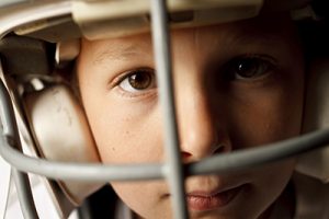 young adolescent wearing a football helmet
