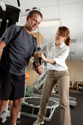 Physical therapist assisting man with shoulder therapy